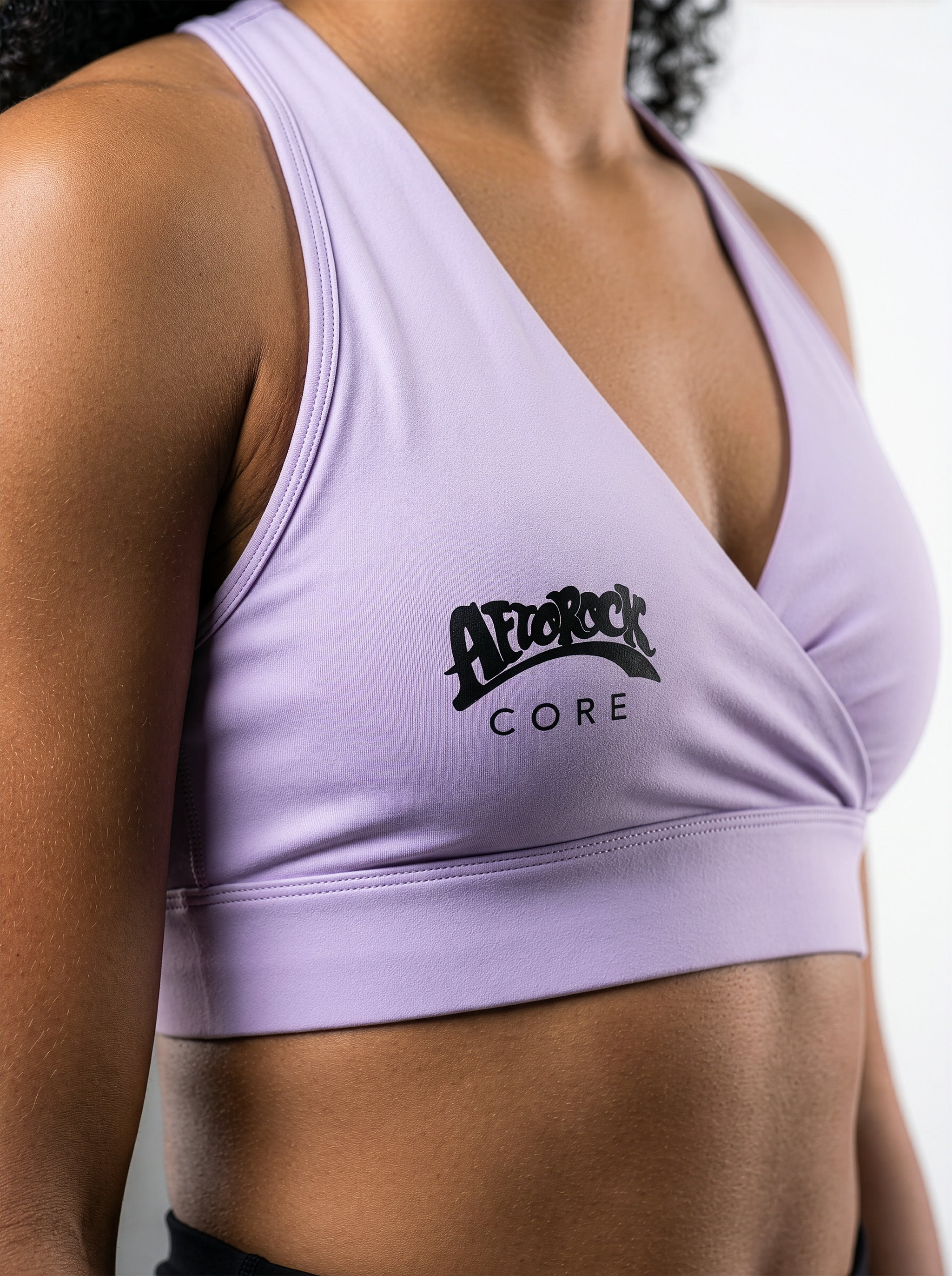 Side View detail of Model Kayla wearing the AfroRock Core Crossover Sports Bra Lavender Purple. Premium streetwear-inspire Purple activewear designed for performance and style.⁠