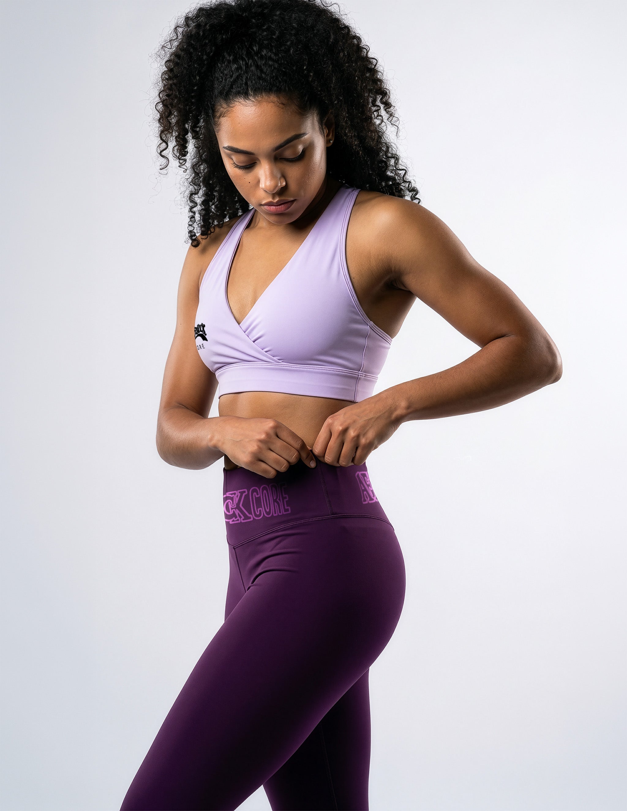 Side view of the AfroRock Core Purple yoga leggings and sports bra on model Kayla, showcasing the premium athletic fit and back branding details.⁠ 