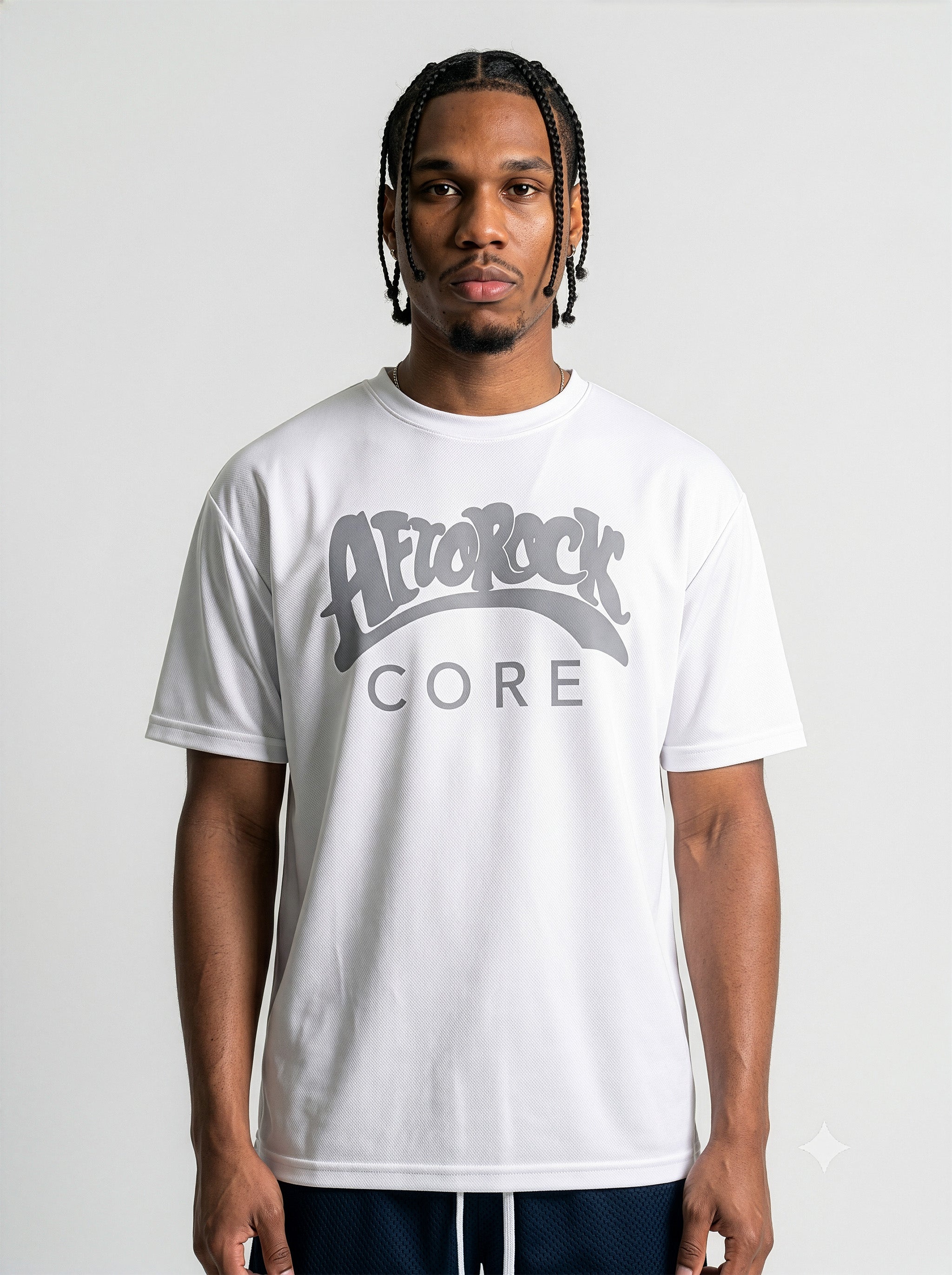 Commercial studio catalog photography of model Jason featuring sharp box braids, wearing the AfroRock Core Performance T-Shirt in White. Low-angle front-facing view highlighting the minimalist crewneck collar detailing, structured shoulders, and athletic drape of the performance fabric. Clean high-key medium-gray studio background.