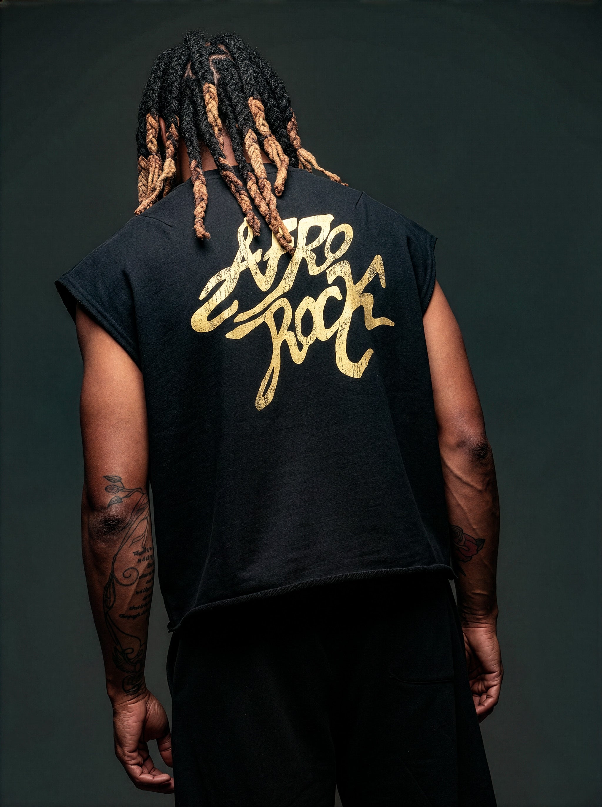 Back view of Kal AfroRock wearing the signature Mazi Skull Horns Boxy Tank. This premium streetwear piece features original hand-drawn artwork with a unique crackle effect and bold AfroRock branding.⁠
