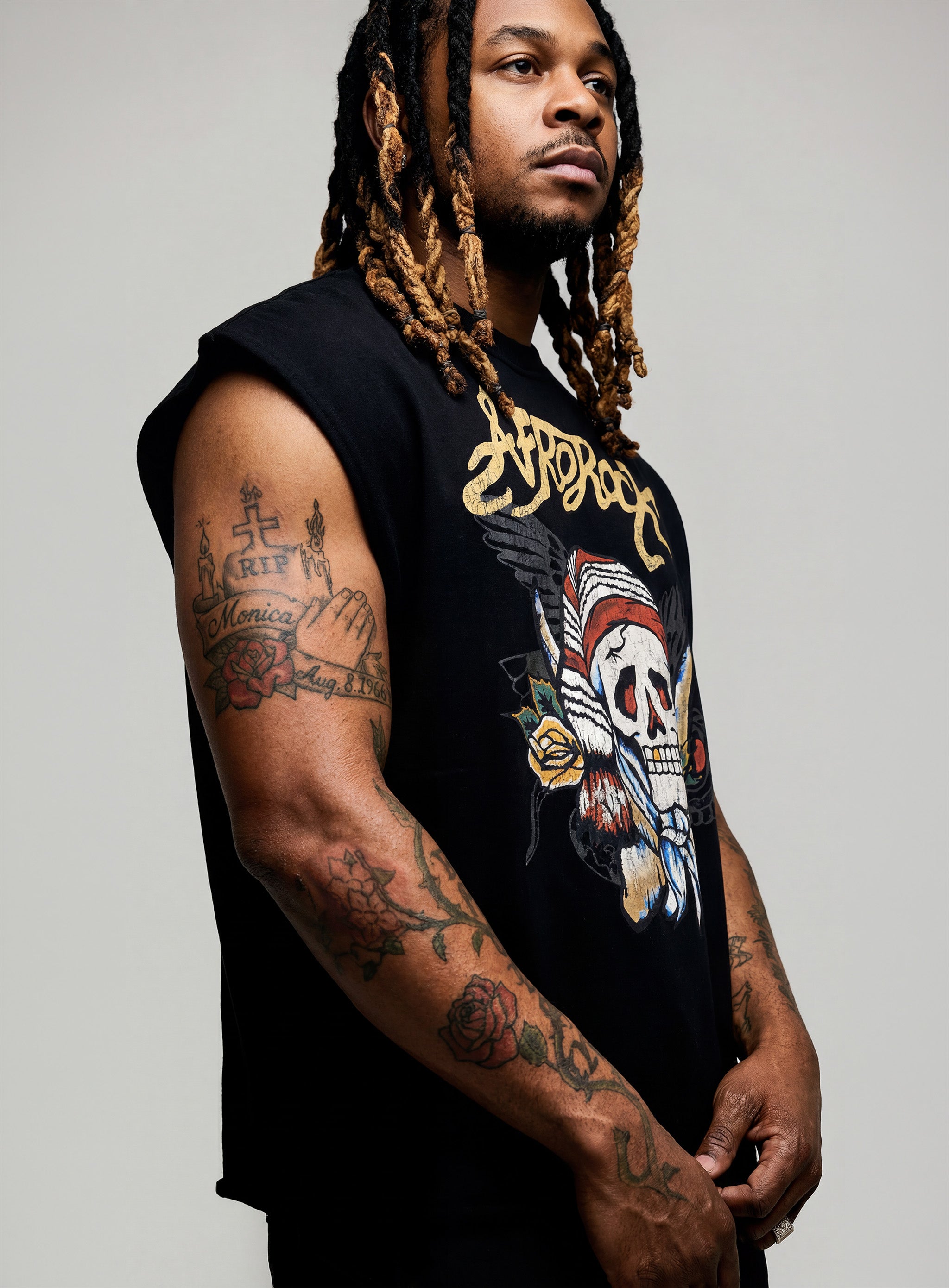 side view of Kal AfroRock wearing the signature Mazi Skull Horns Boxy Tank. This premium streetwear piece features original hand-drawn artwork with a unique crackle effect and bold AfroRock branding.⁠
