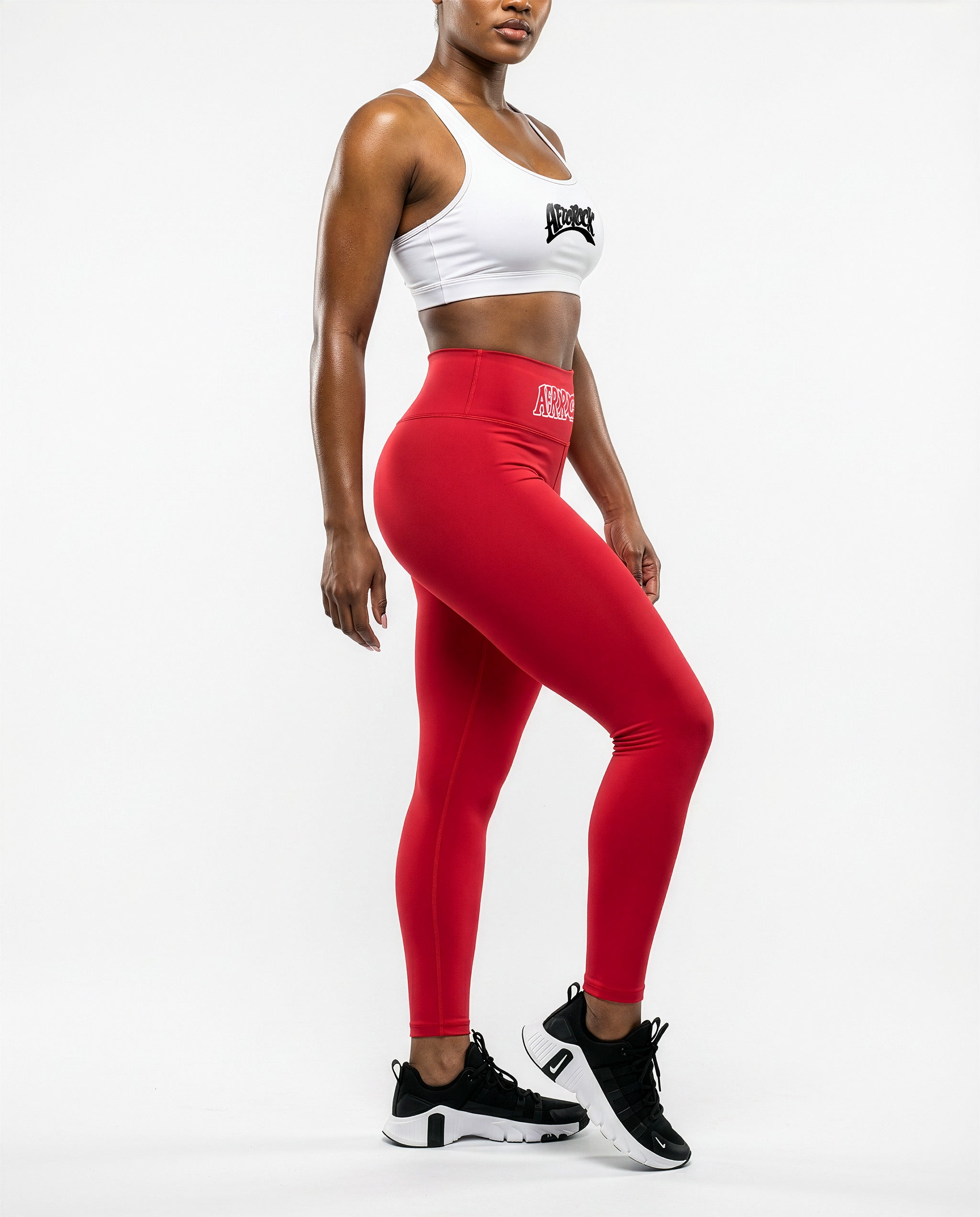 Side view of the AfroRock Core red yoga leggings and sports bra on model Nina, showcasing the premium athletic fit and back branding details.⁠ 