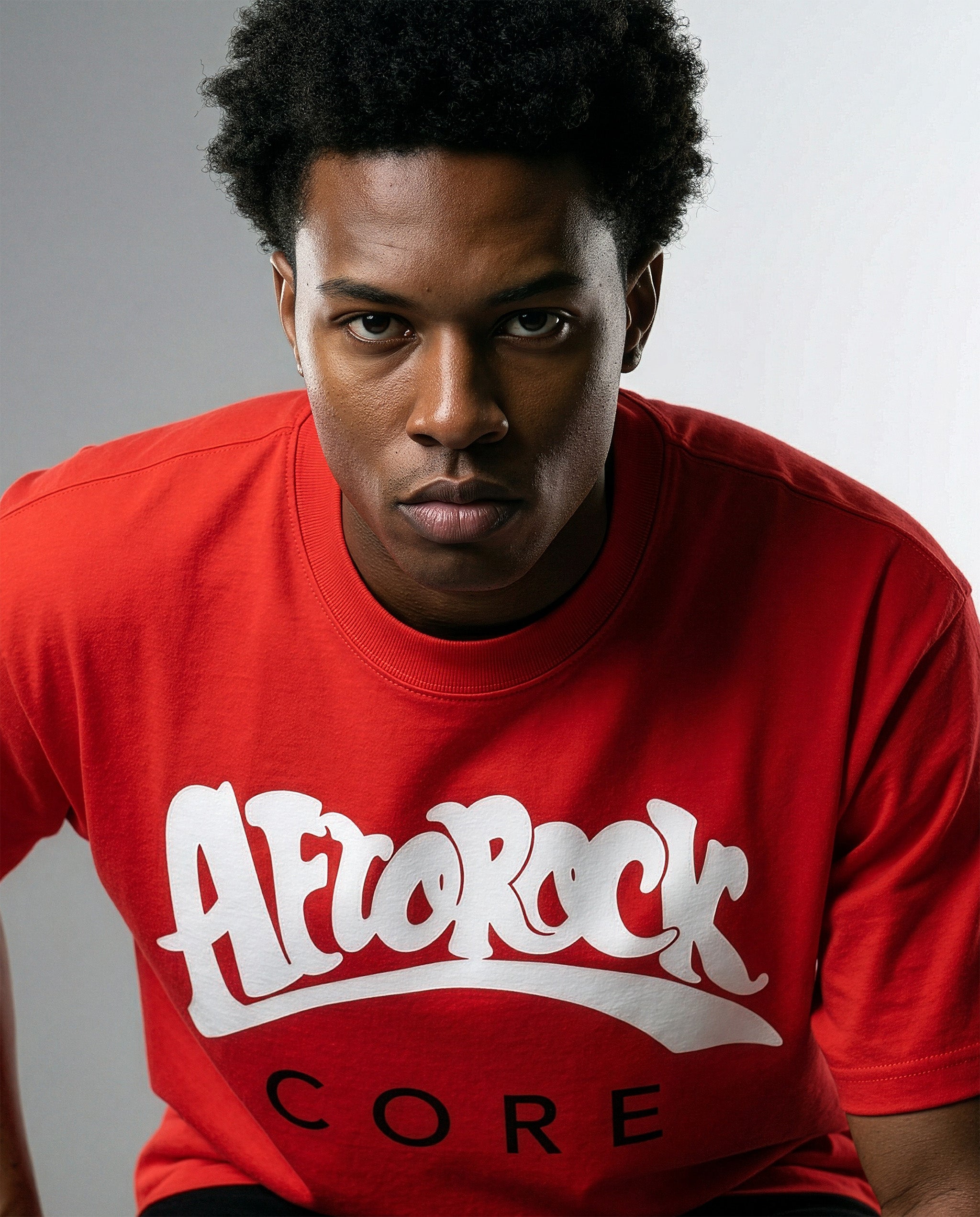 Model Terrell in the AfroRock Core Sorona Quick-Dry Cooling T-Shirt in Crimson Red. Sustainable midweight streetwear graphic tee featuring advanced plant-based eco-fiber technology and bold chest branding by AfroRock.