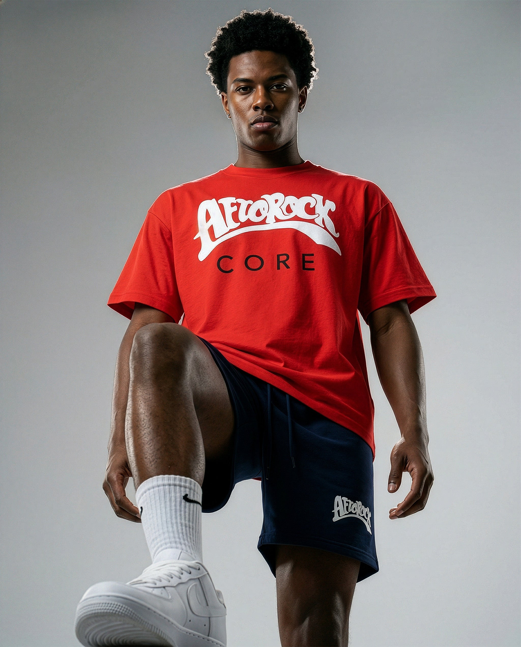 Model Terrell in the AfroRock Core Sorona Quick-Dry Cooling T-Shirt in Crimson Red. Sustainable midweight streetwear graphic tee featuring advanced plant-based eco-fiber technology and bold chest branding by AfroRock.