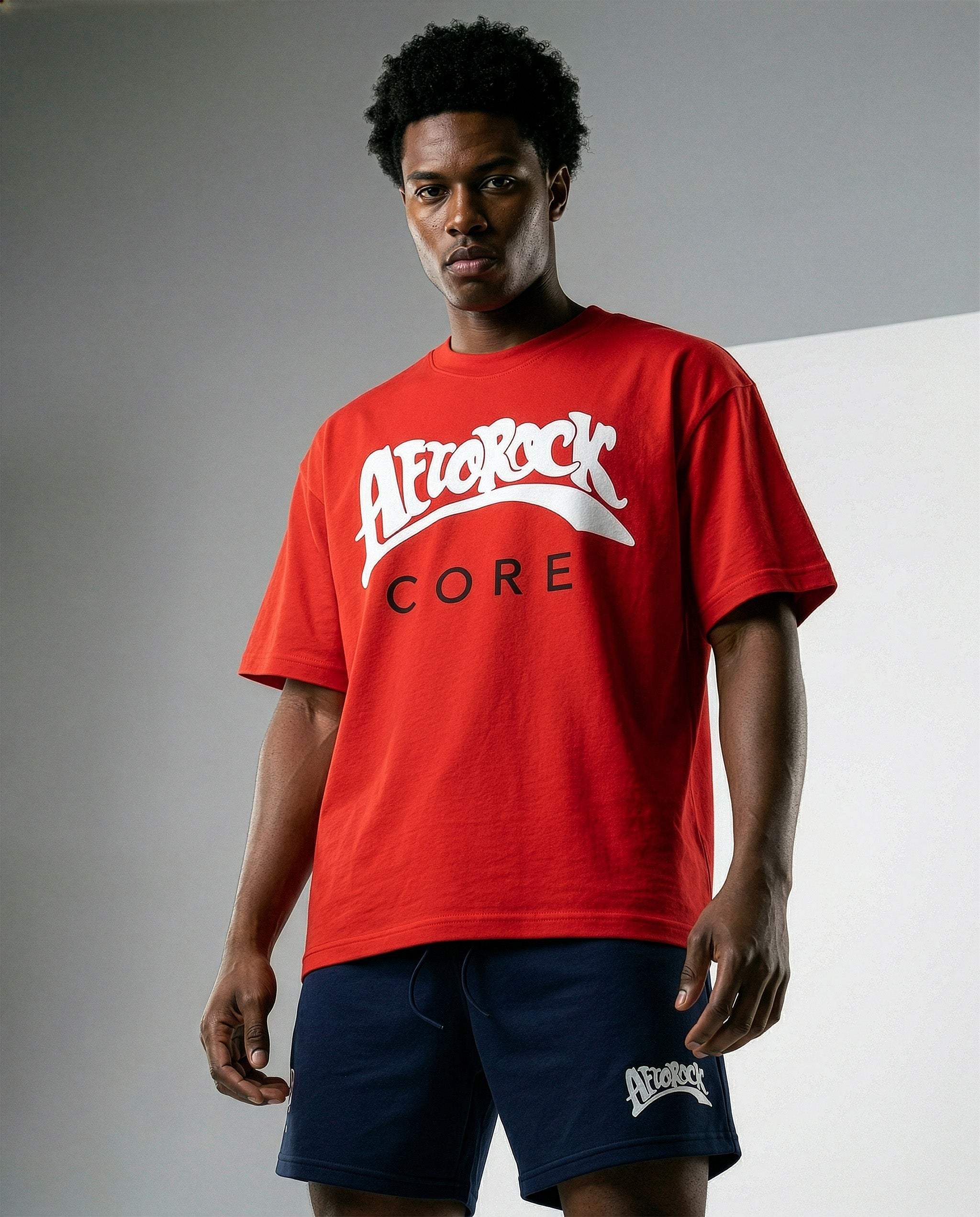 Model Terrell in the AfroRock Core Sorona Quick-Dry Cooling T-Shirt in Crimson Red. Sustainable midweight streetwear graphic tee featuring advanced plant-based eco-fiber technology and bold chest branding by AfroRock.
