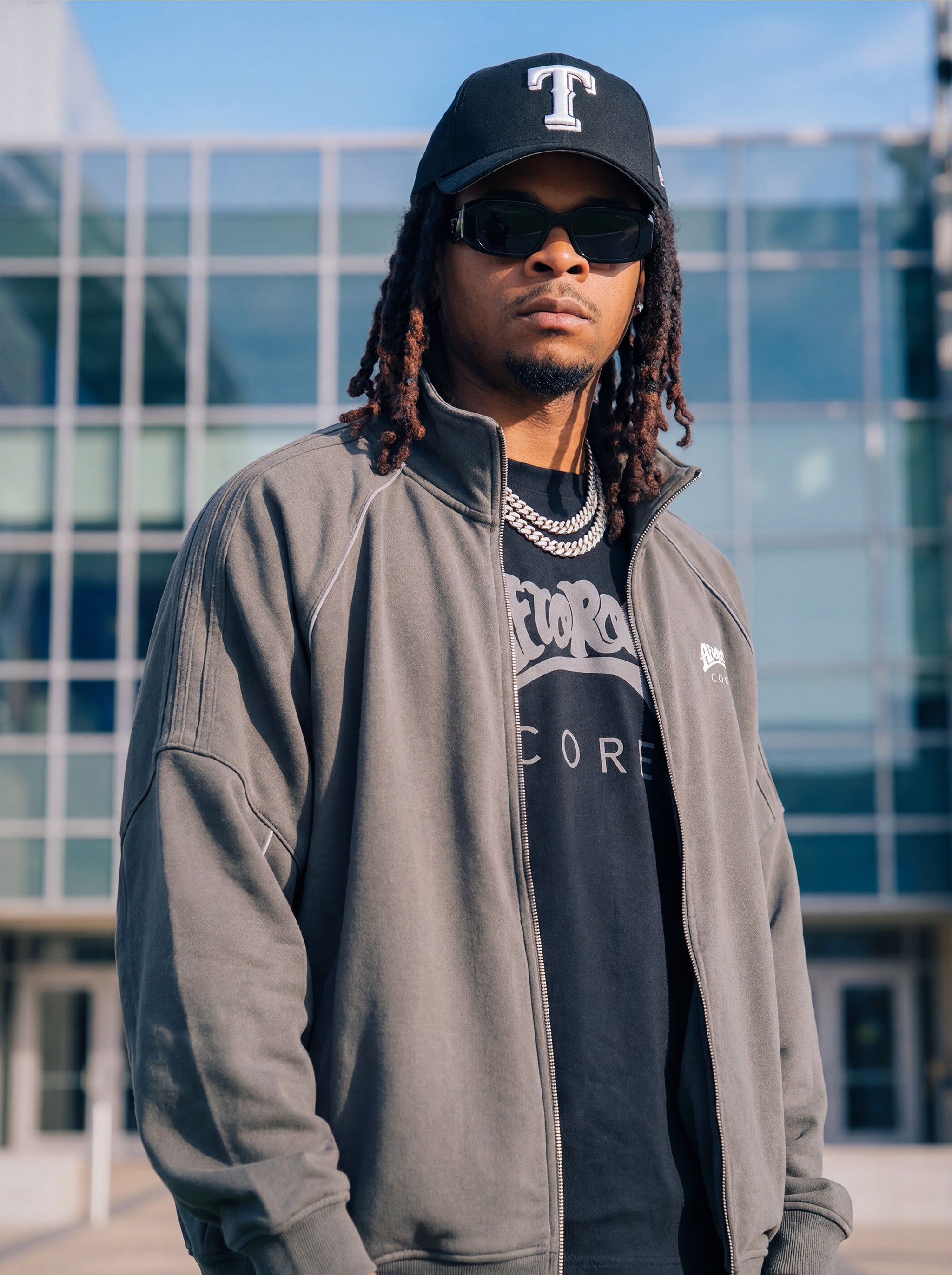 Kal Afrorock wearing the AfroRock Core Reflective Striped Jacket Gray and Black Tee, showcasing the premium streetwear fit and branding details.⁠ 