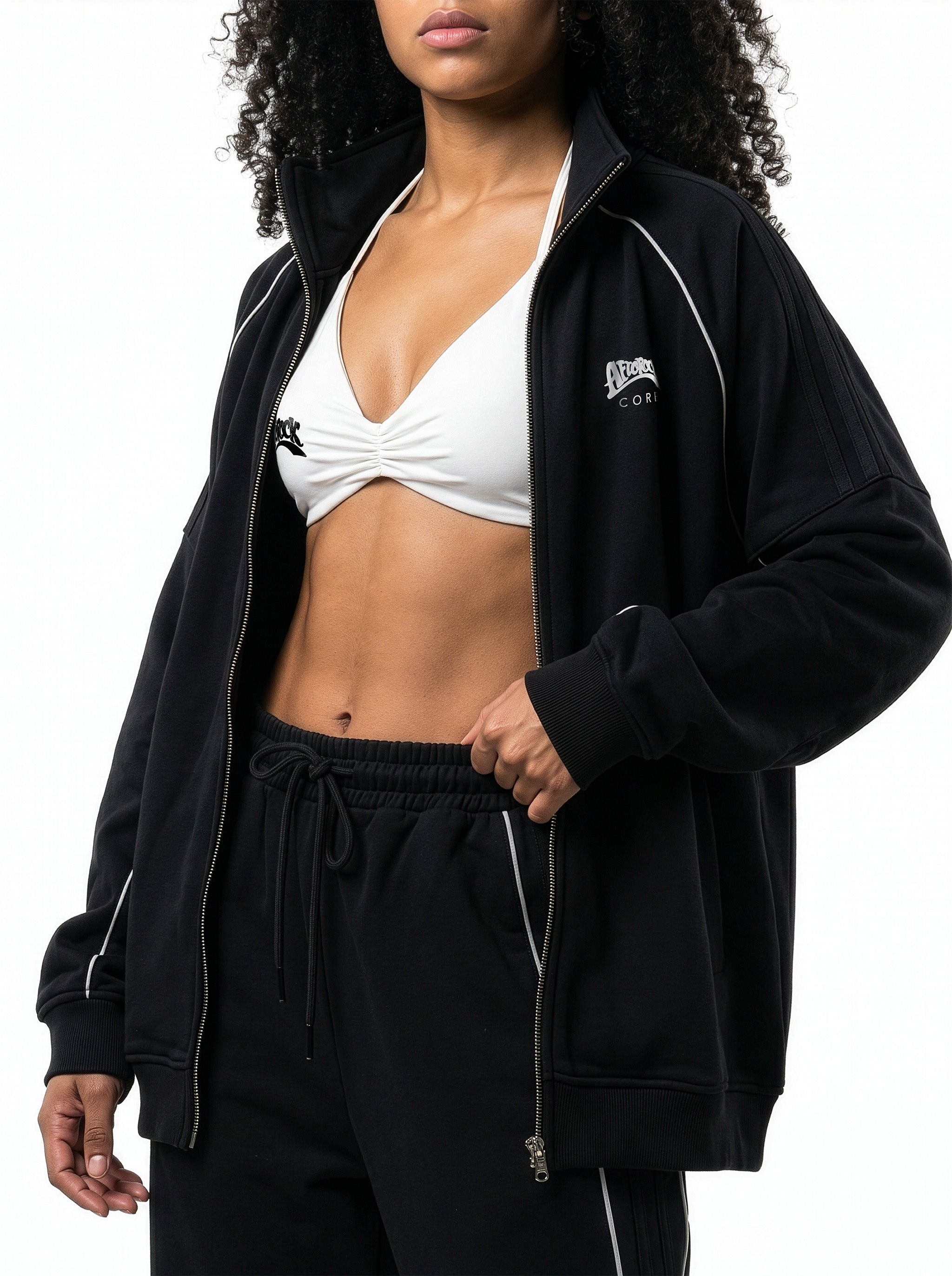 Side view of the AfroRock Core Reflective Striped Jacket black Set and White Sports Bra on model Kayla, showcasing the premium streetwear fit and branding details.⁠ 