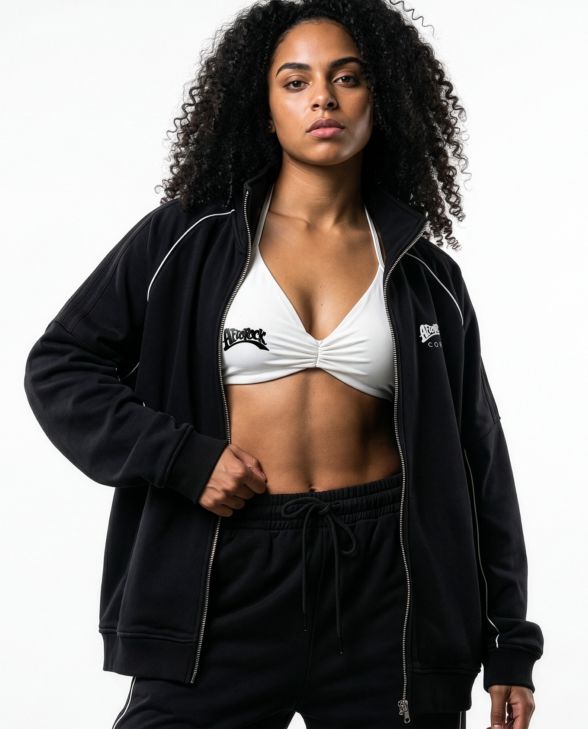 Front detail of the AfroRock Core Reflective Striped Jacket black Set and White Sports Bra on model Kayla, showcasing the premium streetwear fit and branding details.⁠ 