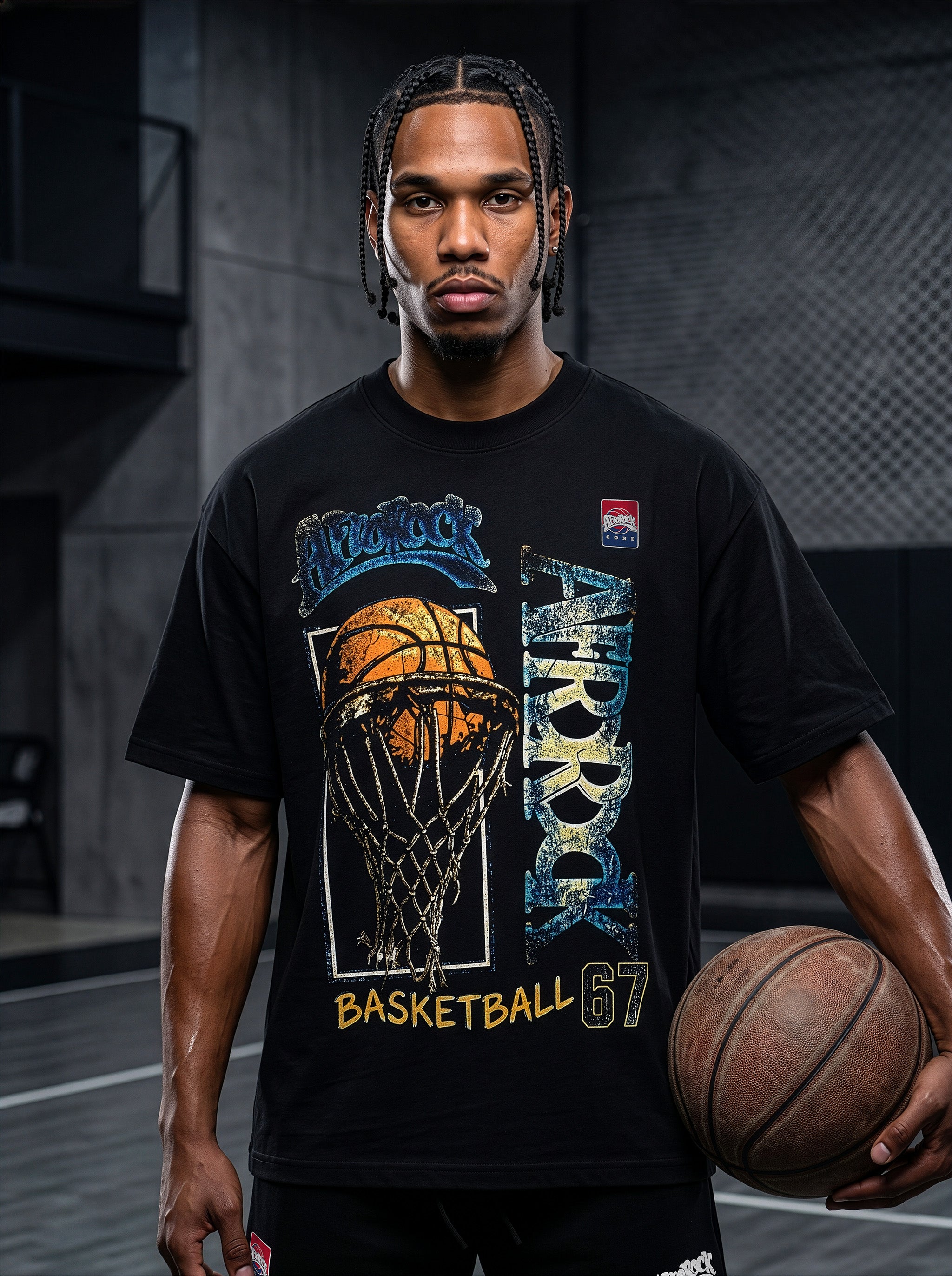 Studio product photography of model Jason in the AfroRock Core streetwear collection. He wears the AfroRock Basketball Vintage Graphic Tee in Pitch Black, an oversized 260gsm cotton shirt with an expansive front graphic of a basketball and hoop, a vintage weather-crackle print finish, and an athletic team badge. Industrial studio lighting highlights a premium sport-heritage lifestyle aesthetic.