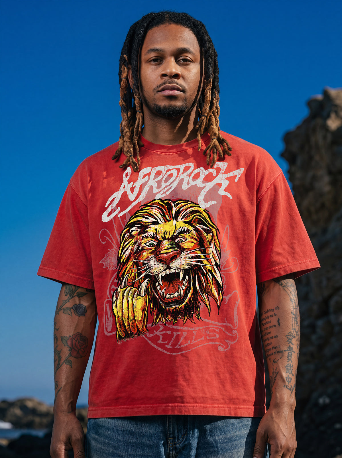 Brand founder Kal Afrorock modeling the AfroRock Ishiagu Vintage Mineral Wash Boxy Tee in Fade Crimson. Premium 360gsm heavyweight cotton streetwear t-shirt featuring a custom hand-drawn West African Ishiagu Lion graphic.