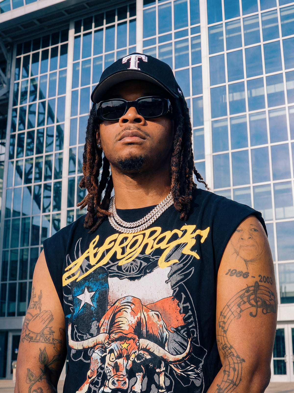 Front Side view of Kal AfroRock wearing the signature Longhorn Texas Raw Edge Tank Black. This premium streetwear piece features original hand-drawn artwork with a unique crackle effect and bold AfroRock branding.⁠