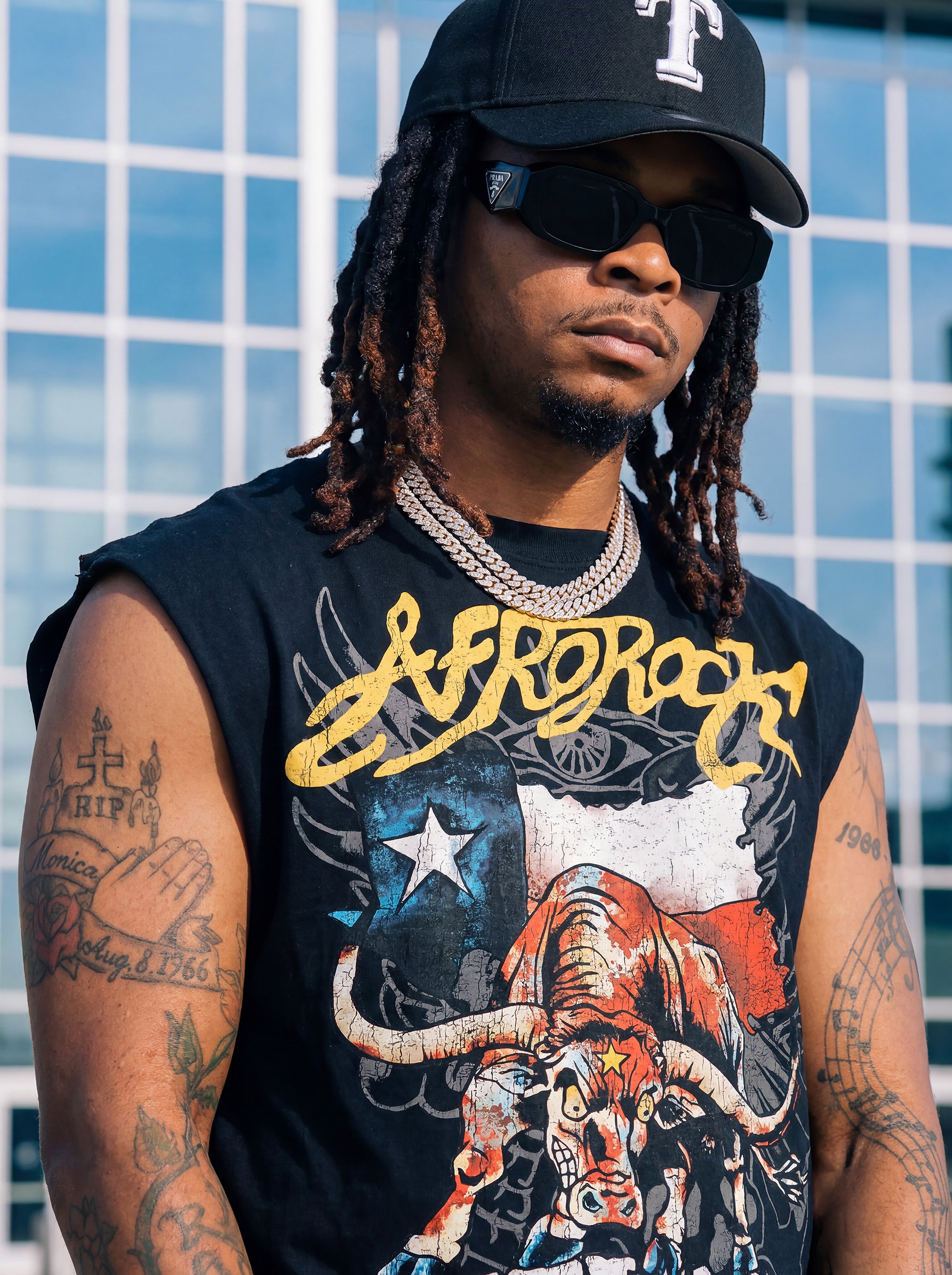 Front Side view of Kal AfroRock wearing the signature Longhorn Texas Raw Edge Tank Black. This premium streetwear piece features original hand-drawn artwork with a unique crackle effect and bold AfroRock branding.⁠