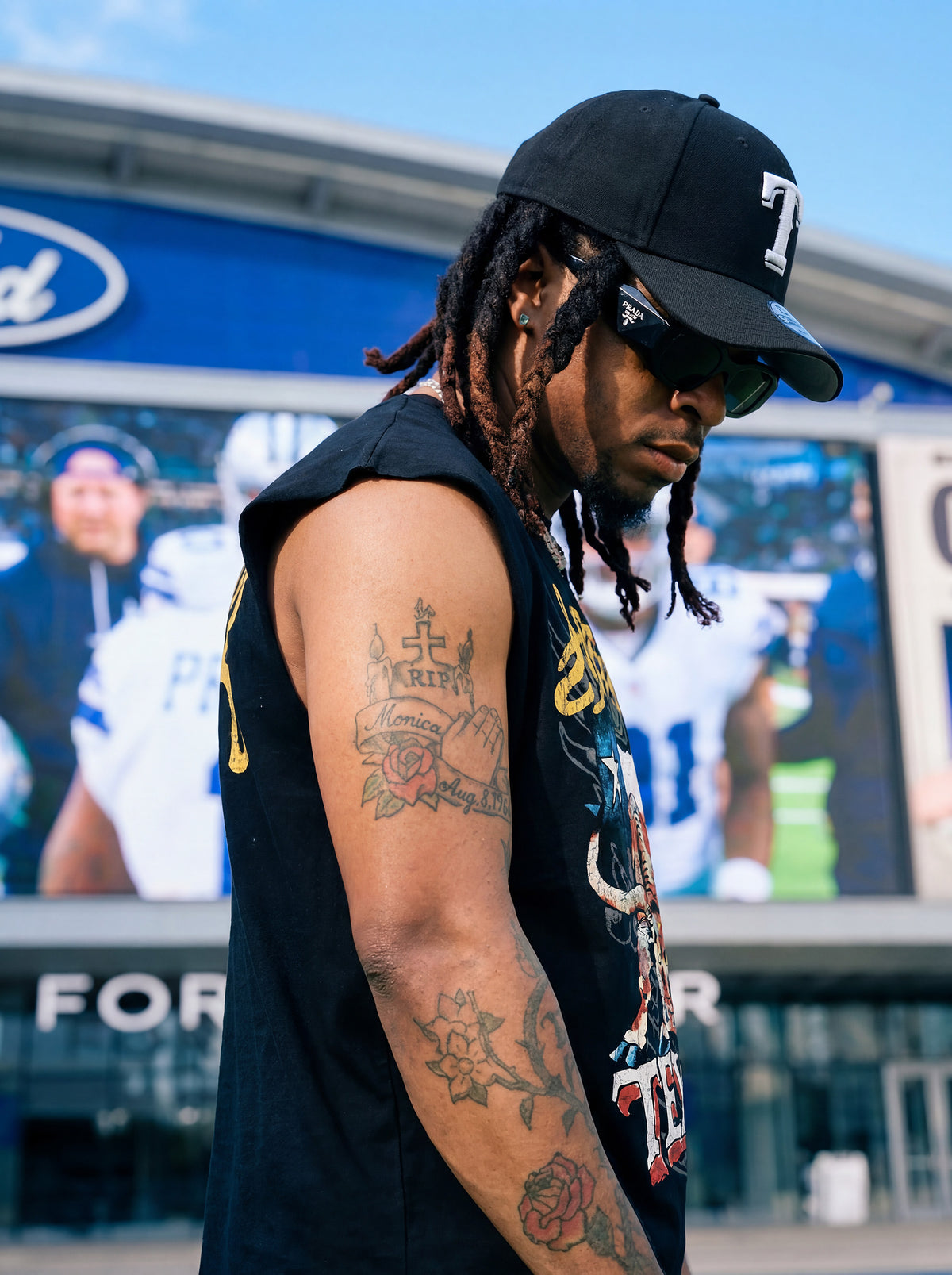 Side view of Kal AfroRock wearing the signature Longhorn Texas Raw Edge Tank Black. This premium streetwear piece features original hand-drawn artwork with a unique crackle effect and bold AfroRock branding.⁠