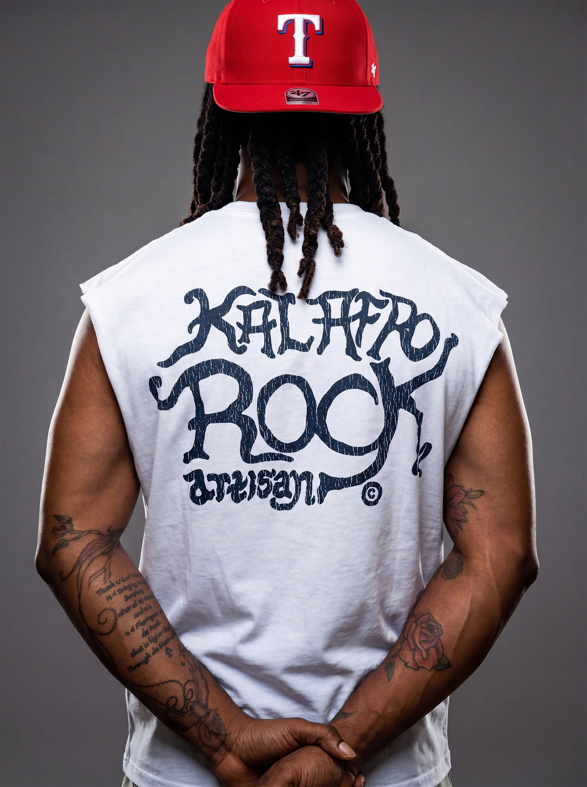 Rear view of Kal AfroRock wearing the signature Longhorn Texas Raw Edge Tank. This premium streetwear piece features original hand-drawn artwork with a unique crackle effect and bold AfroRock branding.⁠