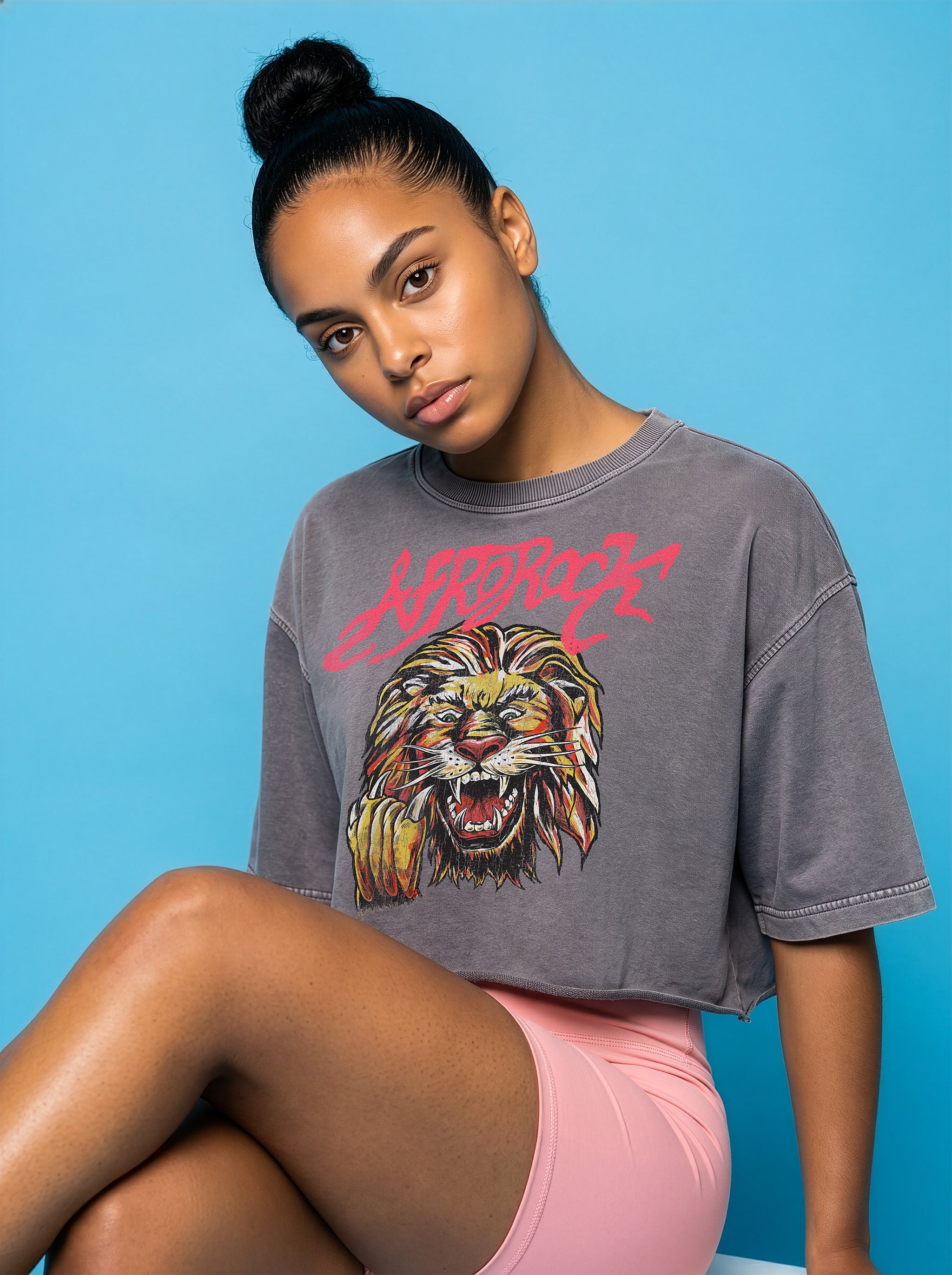 Seated Front view of the AfroRock Ishiagu Washed Raw Edge Gary Crop Top and Pink High-Waisted Biker Shorts on model Kayla, showcasing the premium streetwear fit and branding details.⁠ 